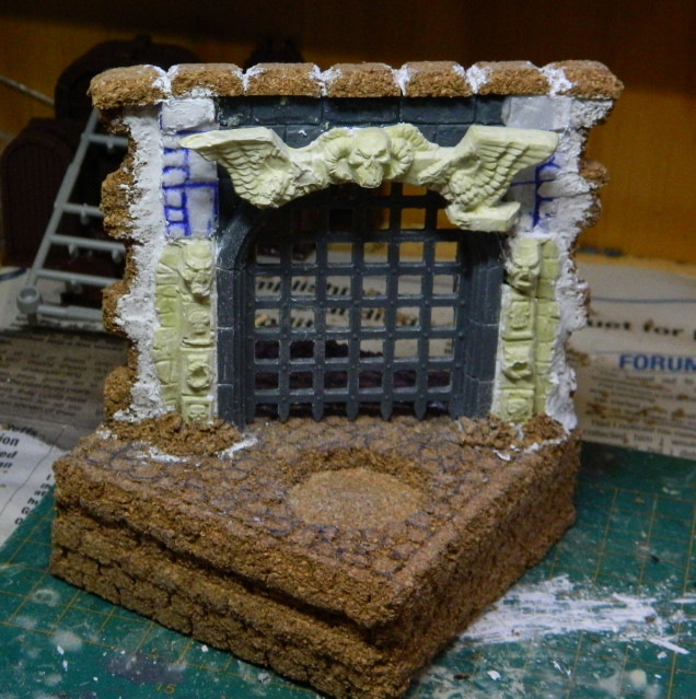 Cork bricks on top and up the sides to indicate that this was once part of another structure. Cork crumbs have been glued around the base to blend it in.