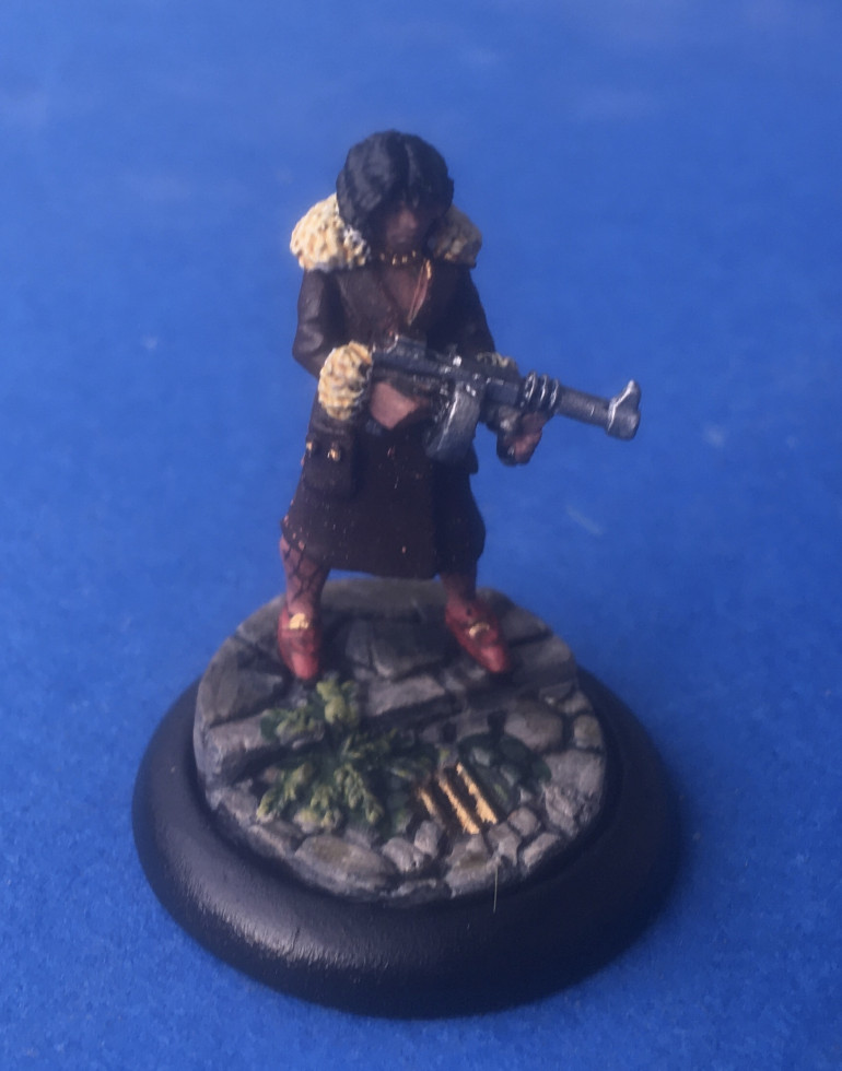 “Victoria Valentine” - Miniature chosen Copplestone Castings ‘Gun Moll’ SKU GN7 sculpted by Mark Copplestone. Mounted on a Wyrd Miniatures’s cobbled street 30mm base. 