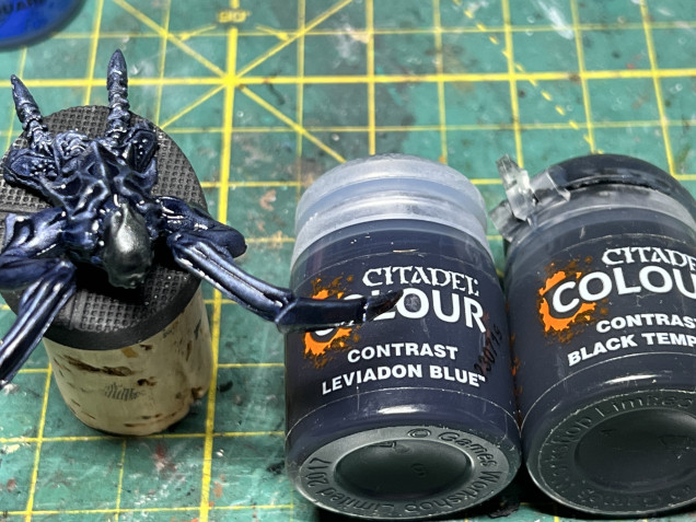 The body received a coat of GW Contrast Leviadon Blue and the head a coat of GW Contrast  black templar. The metallic drybrush applied in the previous step becomes very visible at this stage.