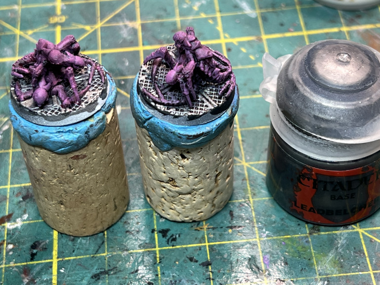 Once dry, drybrush with a pink color (here, GW Emperor's Children) and apply a drybrush of GW Lead Belcher to the base.