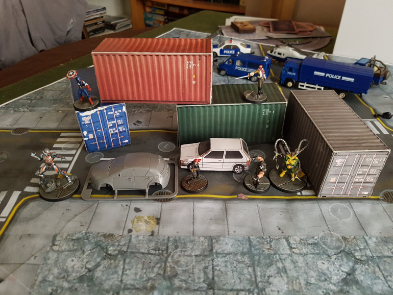 A papercraft container and car with some models and plastic terrain for scale