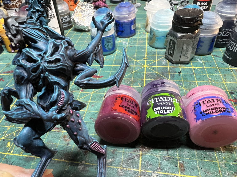 The inside of the mouth, membranes and leg protrusions are painted using GW Screamer pink, washed in GW Druchi Violet and highlighted with GW Emperor Children