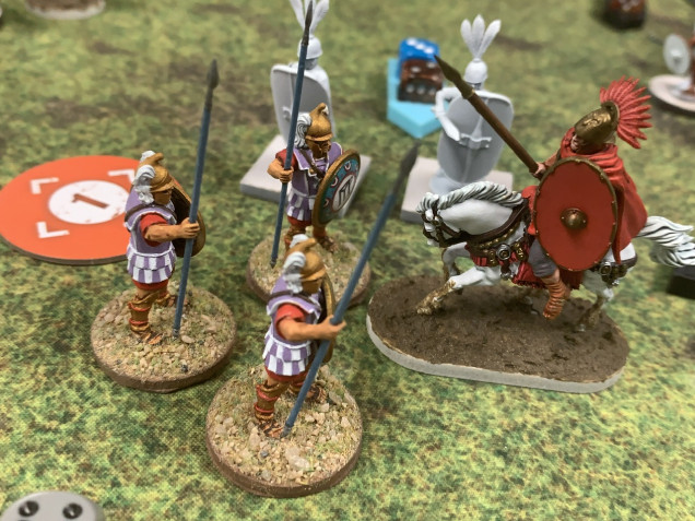 The Hypaspists failed to finish off the Romans who managed to make almost all their combat saves, armor saves and grit saves. Now exhausted, the Roman leader charged in. 