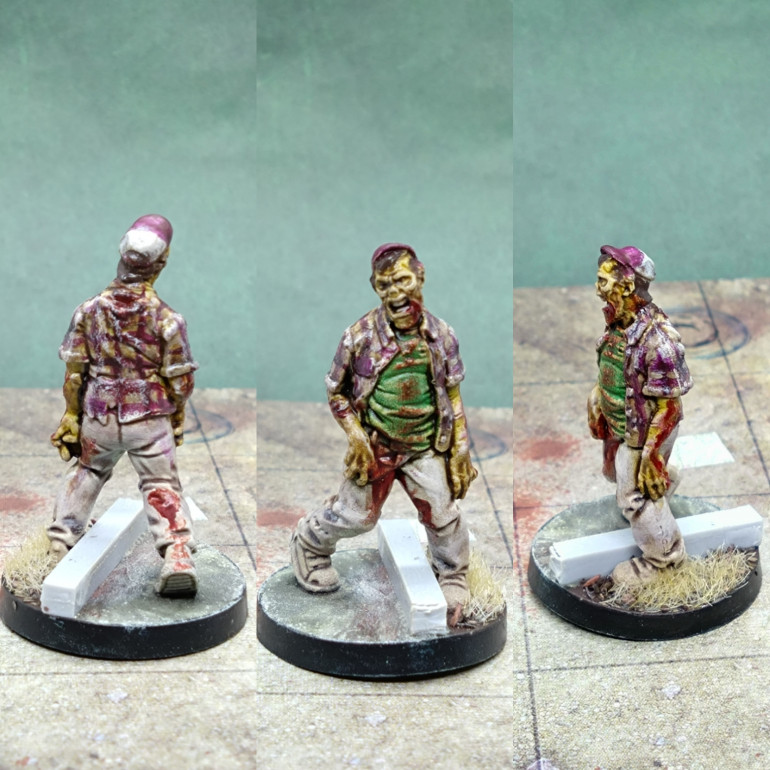 Then to keep the variety going I went for some plaid. The red lines were painted on over a Speedpaint of Pallid Bone. Then when I added a wash of Targor Rageshade a couple of the red lines began to be rubbed away and one red line moved. I tidied it up again and it actually looked more worn and grotty as zombie clothes should be. The basing was fun. Some dead grass and a chunk of resin as a curb.