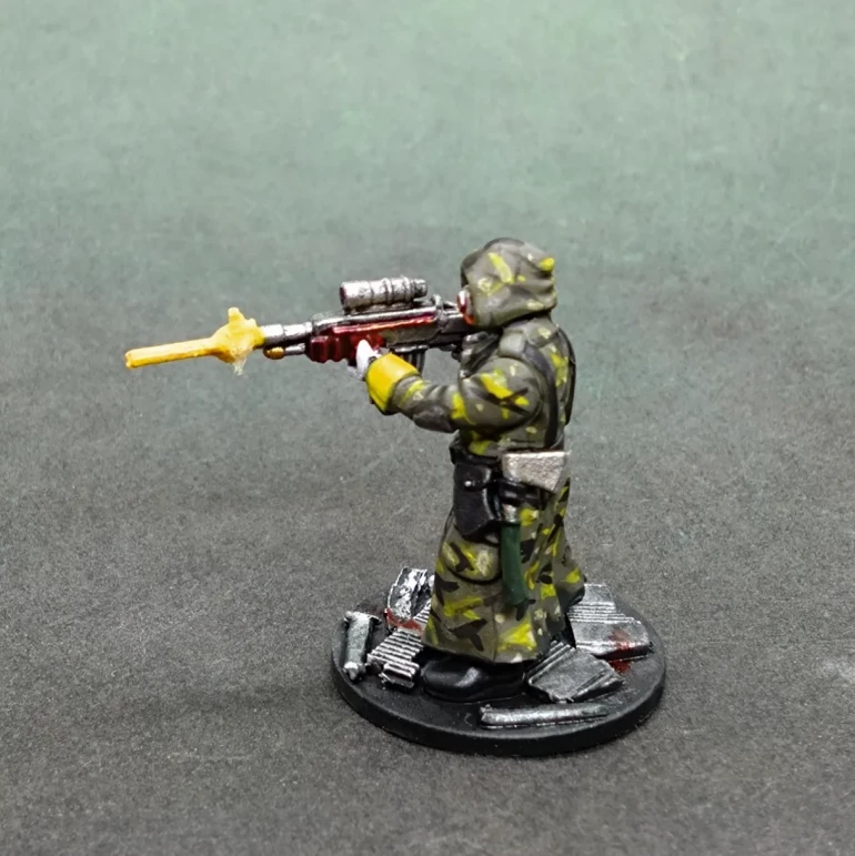 I know that bright yellow cuffs ruin the camo scheme, but to keep him in keeping with the rest of his crewmen I kept the cuffs, black webbing and snipers require a hand weapon so an axe from the latest Scavenger box fitted the bill. (Solubrian pun intended.)