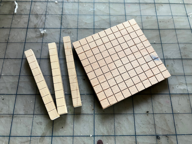 The square pieces are divided into a grid of 100 squares while the posts are 10 squares each.