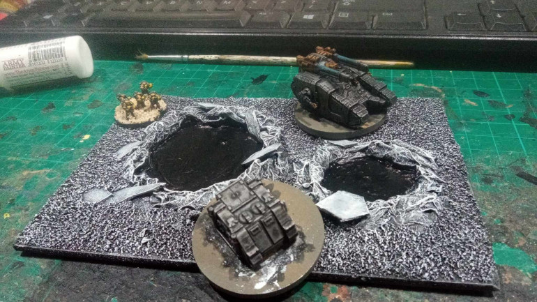 Some miniatures for scale. A Sicaran sized hole full of water is pretty good for blocking terrain, this is teh smallest crater set that I've make, there's a massive crater that should stop even a Titan on my painting desk.