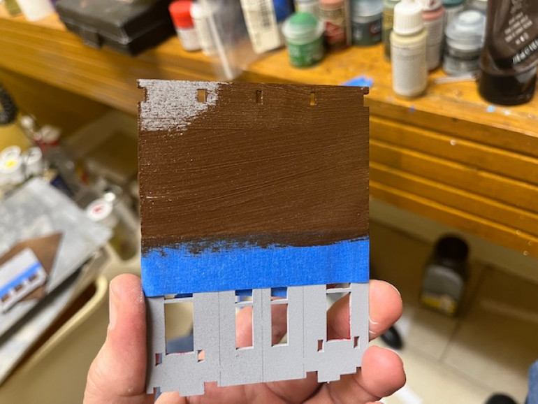 I masked the front walls to get a nice straight line and then painted the upper part of the false front the standard wood color I’ve used throughout the project.