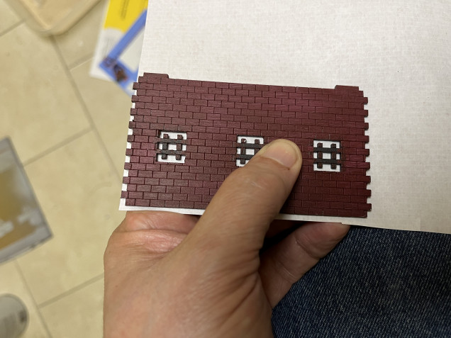 After printing out the brick pattern, I just cut out a section slightly larger than the wall by holding the wall up against the paper and then just trimming it down. 