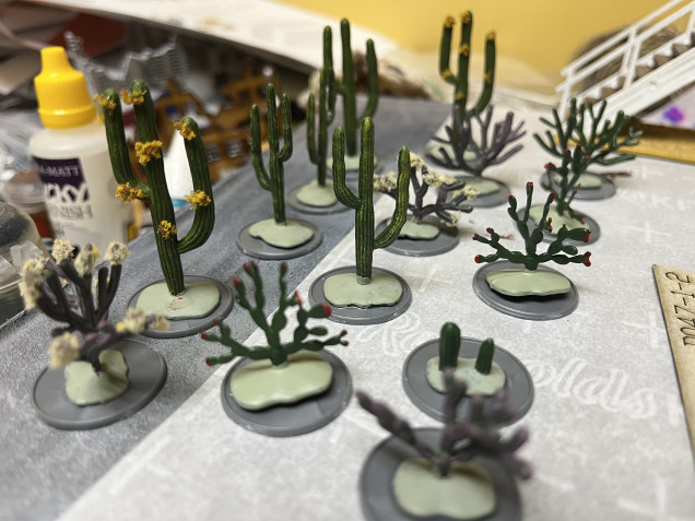 I also started working on some cactus too. I got these from the train section of the local hobby store. Annoyingly the plants are glued to a foam base inside of a plastic package. They also have extensions that protrude from the base. So I had remove the rubber glue and trim the stems. I then glued them to some Warlord Games recessed bases. 