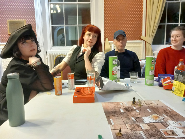 Casual photo of some of the players. We used a suitable hat to mark the player who went first each round and it made its way around the table 