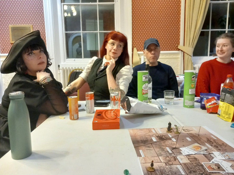 Casual photo of some of the players. We used a suitable hat to mark the player who went first each round and it made its way around the table 