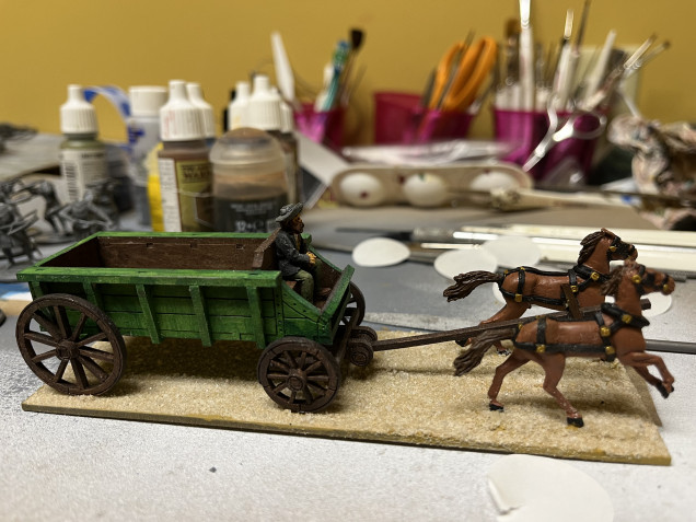 With the base covered in PVC glue, I covered it in sand. I briefly added the wagon to mark where the wheels will make contact with the base. 
