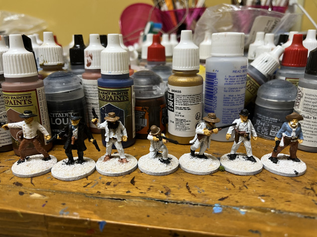 After applying sand to the base with PVA glue i did a white primer. Here I’ve started to paint the faces and hands