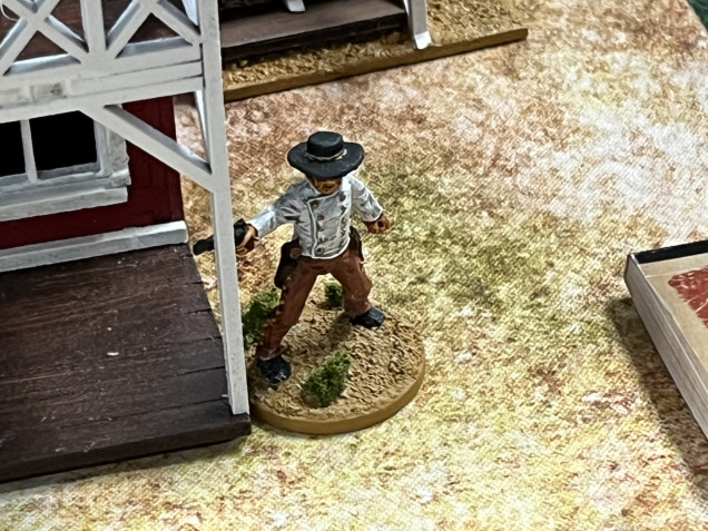 Outlaw Charlie Prince comes around one side of the saloon to cover the approach to the stagecoach. 