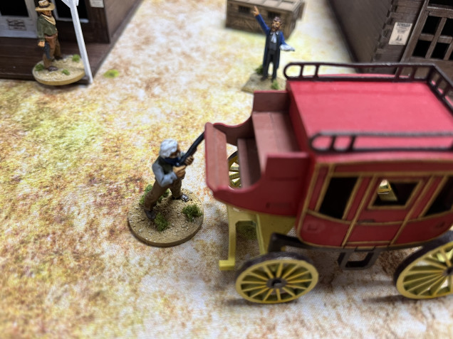 Boss Spearman takes cover behind the stagecoach while Charlie Waite moves up to support him.  Meanwhile the preacher exhorts both sides to repent.  