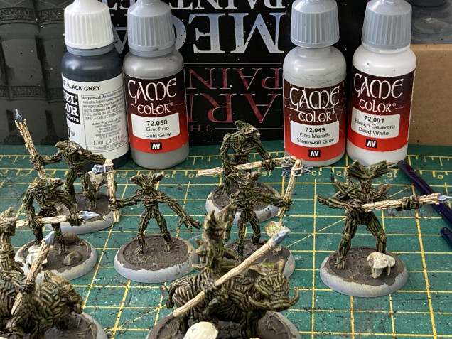 For the weapon heads I wanted a stone effect, as there’s no way these creatures of the forest would be using metal. I started with a very very very dark grey (not black but black grey), followed by progressively lighter drybrushings of cold grey, stonewall grey and dead white.