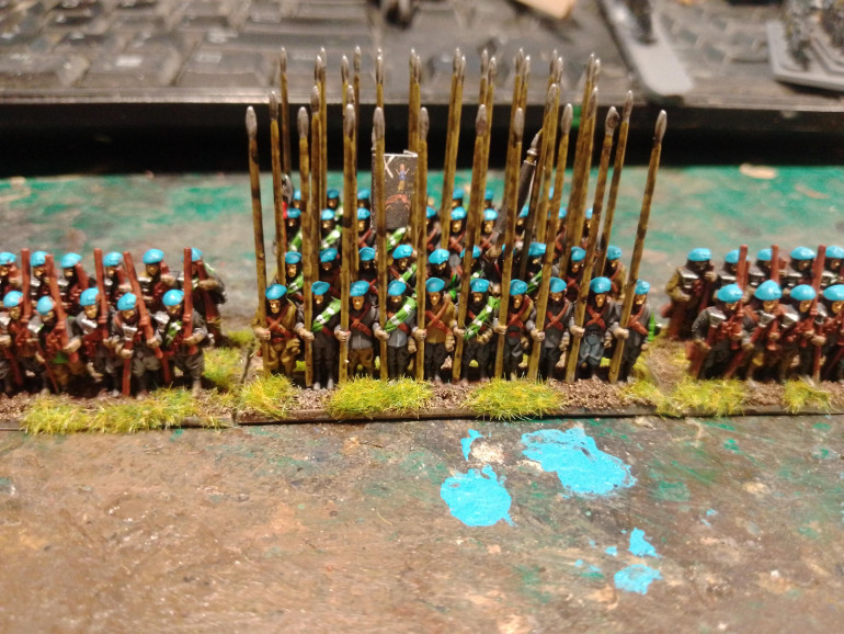 After a black wash, keep it light, paint the white lines for a tartan/plaid effect and light blue bonnets (Troglodyte Blue). Base them with fine sand, Catachan Flesh drybrushed with Khaki and finished with static grass.