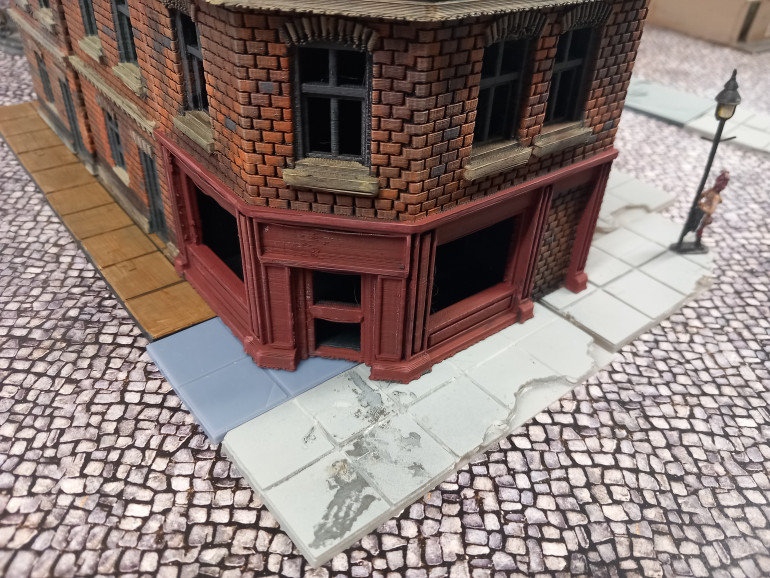 I felt something was missing and it's pavement. I have some home made dungeon tiles that I think work OK as a bade for my building to sit on. They just needed painting.