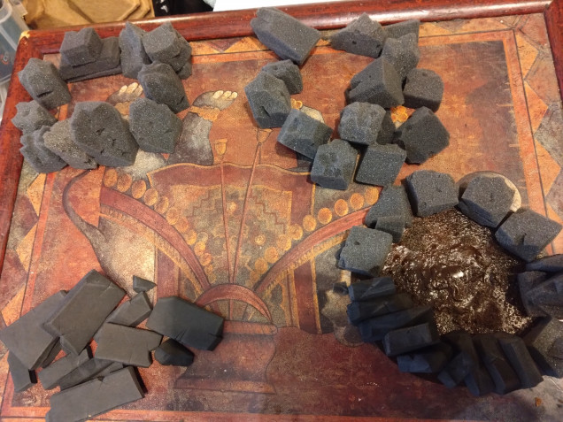 I cut away at the foam squares from miniatures storage boxes. Trying to make it look more natural. I dry fitted the stones in rough circles.