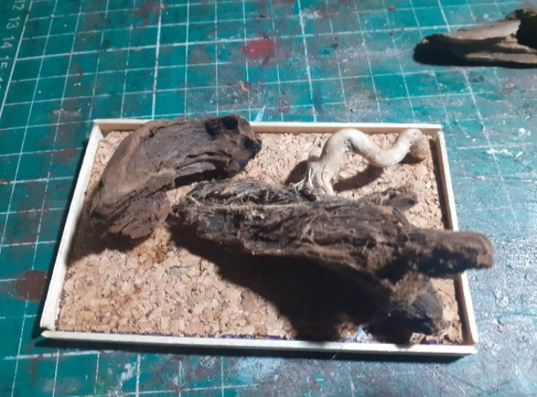 I'm going to need a solid base so looked up the new base size and cut a lump of Cork to size added some lumps of wood then using coffee sticks to create the sides I slapped in some filler to male a nice solid stable base