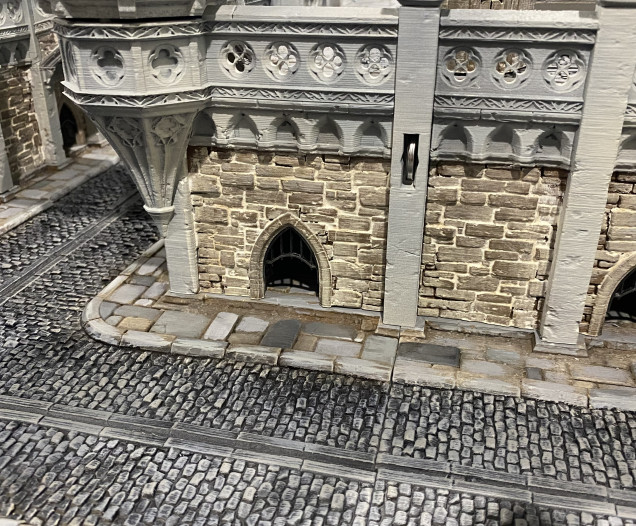 I have repainted the cobblestone road, added small grills to all the arches built into the walls, repainted the curb stones a slightly lighter shade, which I think helps separate the paving from the road sections better.  I also inserted batteries into the pillars for the lighting.