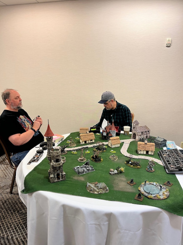 Two of my friends setting up a Deth Wizards table.  This was such a pretty game it drew in a couple of folks who had never played minis games before.  My friend, Linden, has been asking when I will be setting up another minis game because she is hooked.