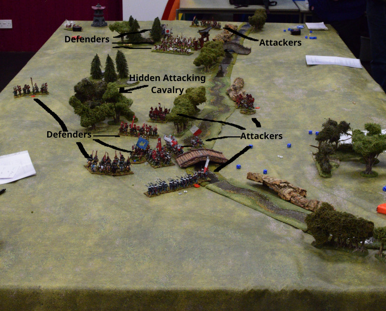 The battle ends with the Attacker’s Ashigaru Yari crossing the river on the Defender’s right, but becoming disordered.  Their Foot Samurai also cross but are disordered.  The Attacker’s central Foot Samurai face off against the Defender’s right flank Foot Samurai.  The Attacker’s devastating central Mounted Samurai are behind the trees and still dangerous.  The Defender’s central force is barely there with only a disordered unit of Foot Samurai left.  The Defender’s right flank force is still intact and their Mounted Samurai are free to move again.  On the Defender’s left their forces are also intact and face a single unit of the Attacker’s Samurai.  Both sides grudging agree on an honourable draw and the Attacker’s withdraw to their own territory.