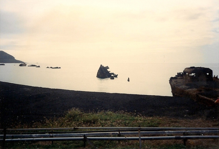 Broken up landing craft. Mt Suribachi in the background.  
