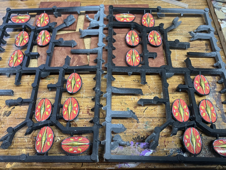 I usually do shields on the sprue and just retouch the edges when on the model. 