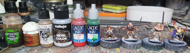 Base with GW Retributor Gold, wash with GW Seraphim Sepia, layer highlight with VMA 71.066 Gold, and finally with that gold mixed with a little VMC 77.707 Chrome. The gems were then undercoated with Chrome, and glazed with 1-2 coats of VGC 72086 Red Ink or VGC 72.089 Green Ink