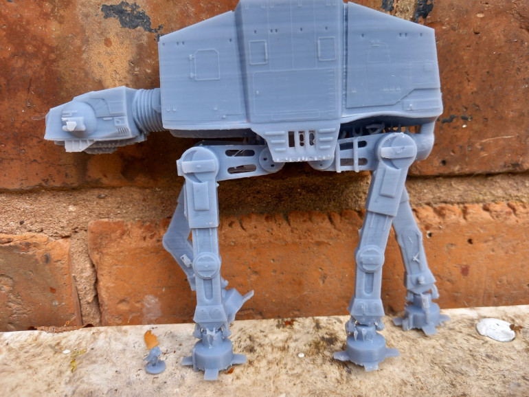 Trolling thingiverse I found files for an at at. It had no supports but I scaled it down to look right next to the little guy at his foot. It printed OK but the guns were too fiddly and snapped off.