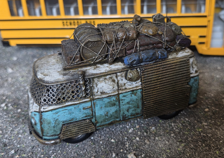 A post apocolyptic  Mystery Machine. The body work was painted in the following way: I started from a black undercoat and drybrushed the following layers to create a rusty metal base, Rhinox hide followed by lighter drybrushes of Mournfang Brown, Orange and finally a very light dry brushed of a gunmetal colour. I then stipled on the base paintwork colours, tidying up with a paintbrush at the end. All other base colours were then painted prior to giving the whole model a wash of Agrax Earthshade. I then built up the paintwork with a combination of stipling and a fine paint brush in progressively lighter shades of the base colour.