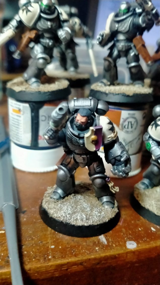 I enoy the aesthetic of the Black Templars, I even enjoy the Borther Cadfael Tonsured haircut and wanted to start a force. However my time spent painting Horus Heresy Dark Angels left me sick of all black army. In response I thought about what I enjoy painting and would look good and came up with the below scheme. 