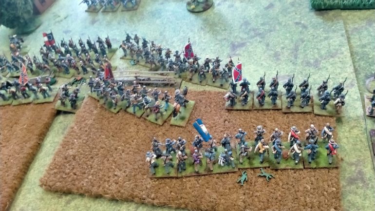 Troops rush to take up firing positions along some fencing.