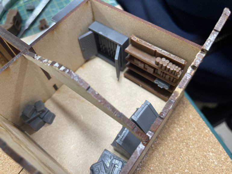 along with a shelving unit stuffed with food and an open gunsafe.