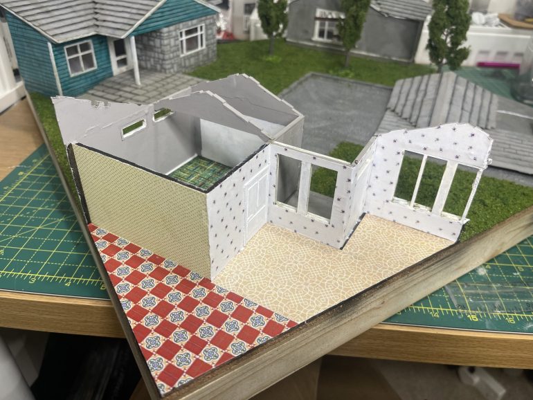 cute out the windows and around doors. easier to do this when glued on rather than eye ball it before sticking down