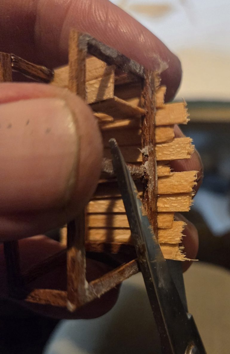 Cutting off the excess wood. Any good scissors cuts through this thin wood. I keep all the excess bits of wood in a tub  makes great battlefield debris.
