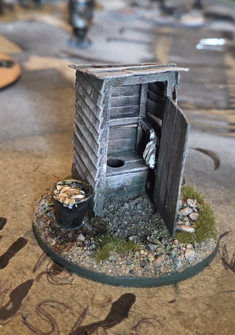 The finished toilet, complete with tags bucket, and clean rags hanging up