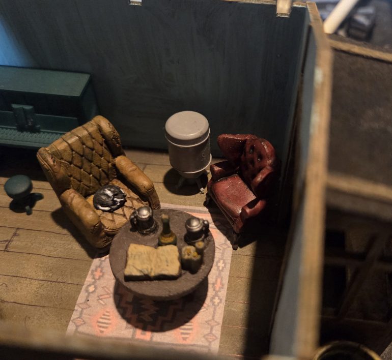 Early draft. The rug is an image I found online, shrunk down and printed. The floor in the cabin was undetailled, so I created a single plank template and drew the planks on with a black biro.