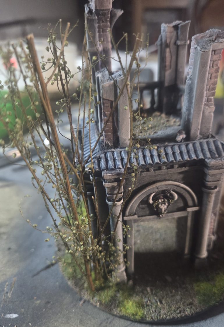 I wanted this shrine/folly to look returned to nature and desecrated. The skull was fastened on to windows with barbed wire, so I just painted as thorns. I also added these cool twigs, about 10 of them in this patch. These are a recent discovery of mine, I cannot remember what they are called, but I love them. I used super glue, applying lots on bottom where twig connected with base, and then selecting contact points against building to further secure. Once I have given a healthy coat of matt varnish will be quite robust. 