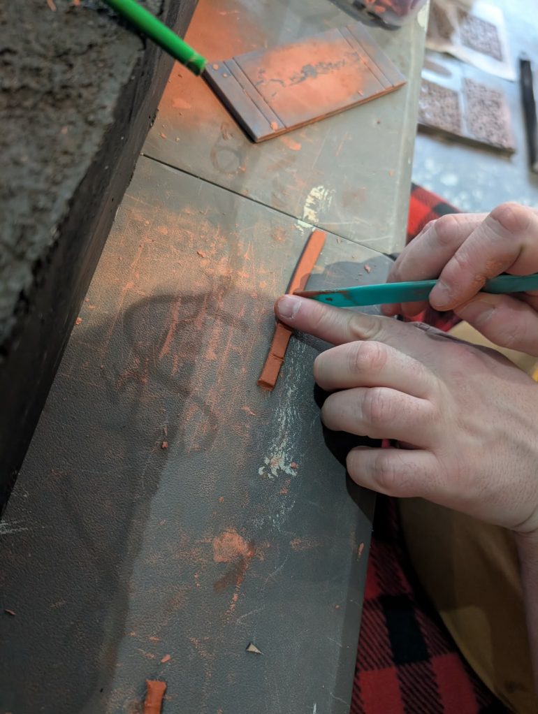 The clay will come out a little rough, so use a small flat surface to give it a quick roll to smooth it out, then, using a standard size, I used my finger, mark out the sandbags