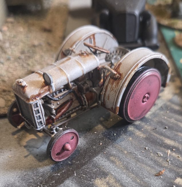 I found this Tractor on ebay, it is 1/43 1922 Fordson F by Hachette, I got this for £8.00 far cheaper than any resin model. I matt vanished it, gave the whole model a coat of Agrax Earthshade,  and once dry an additional coat of Nuln Oil over the engine. I drybrushed up to Brainmater Beige, followed by scratchy edge highlight with a thinned down white. The wheels were drybrushed with progressively lighter shades of red, mixed to match the existing red. Some rust effects, a few additional details on the engine and the steering wheel were completed. All that needs doing is adding pigments to lower half and wheels.