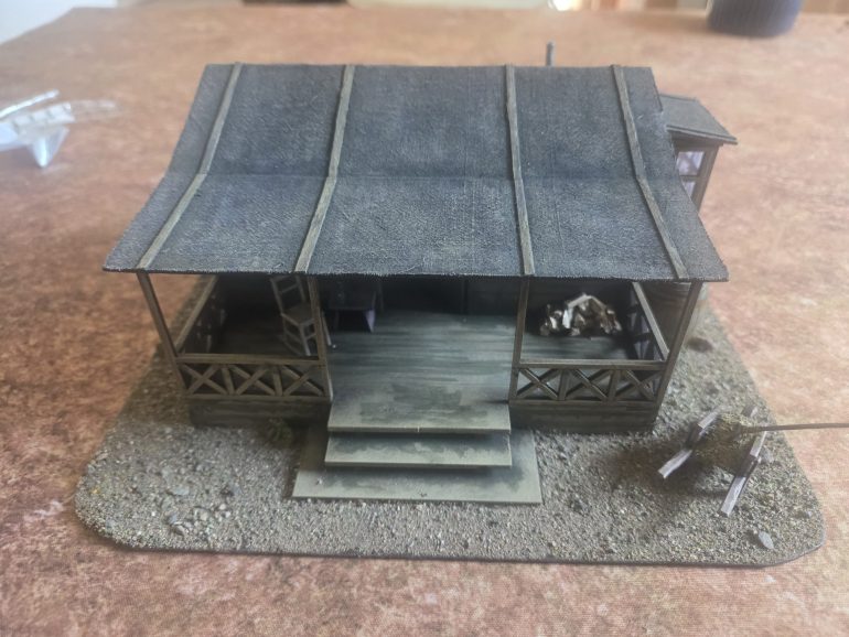 The roof drybrushed up in a mix of khaki and grey, with a green wash around wooden parts to represent dampness.