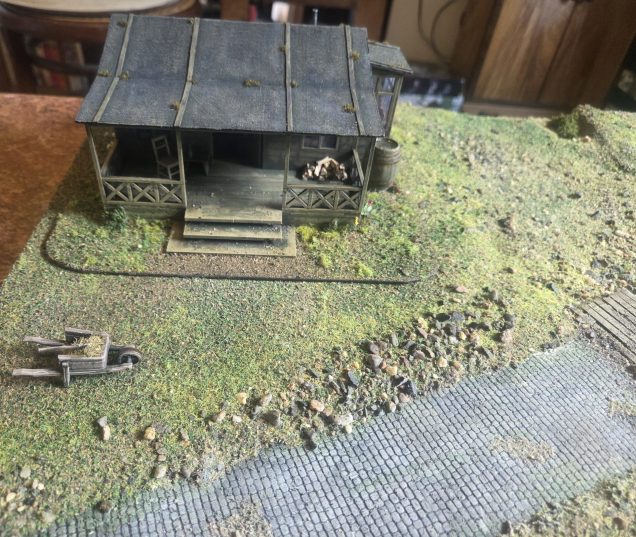 When placing the scenery in my new board I did not like how the base of the house orifinally done with tufts only looked so I took off all the tufts ( fortunately being g the self adhesive variety they peeled of really easily, still took ages) and re did using flocks so it blends in better to the board.