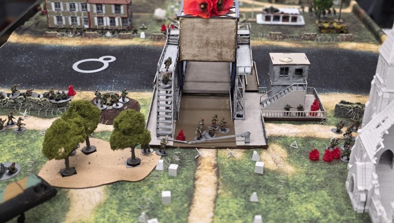 The British assault bogs down, heavy gun fire from and to the bridge control  building.  British  turn the AT gun on the germans