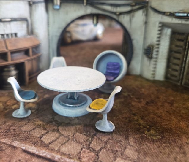 Some lovely chairs from the same Prisoner set with a table made from a warlord 40mm base with ridge removed, a GW base and part of a plunger from a plastic syringe.