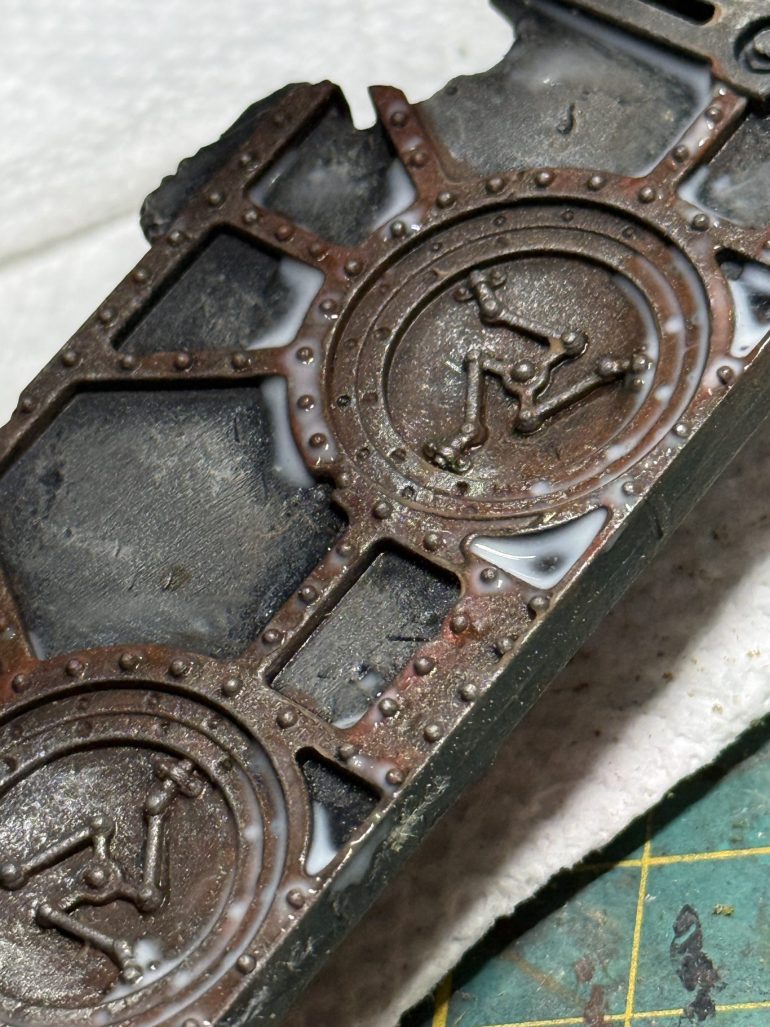 Drench the entire set of ruins in a brown wash. I highly suggest you make your own as it will be far cheaper than hobby washes. Look on YouTube for your favorite formula...I am showing here a wall to wich the wash was applied and which was prepped with white glue in prevision of the next step.