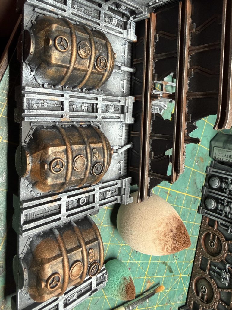 Next you will select other part of the ruins to be painted brass and apply the paint with either a medium brush or a sponge, like I did here for the tanks. I used Brass Scorpion from GW. Other good aras to be painted brass color are pipes and lamps.