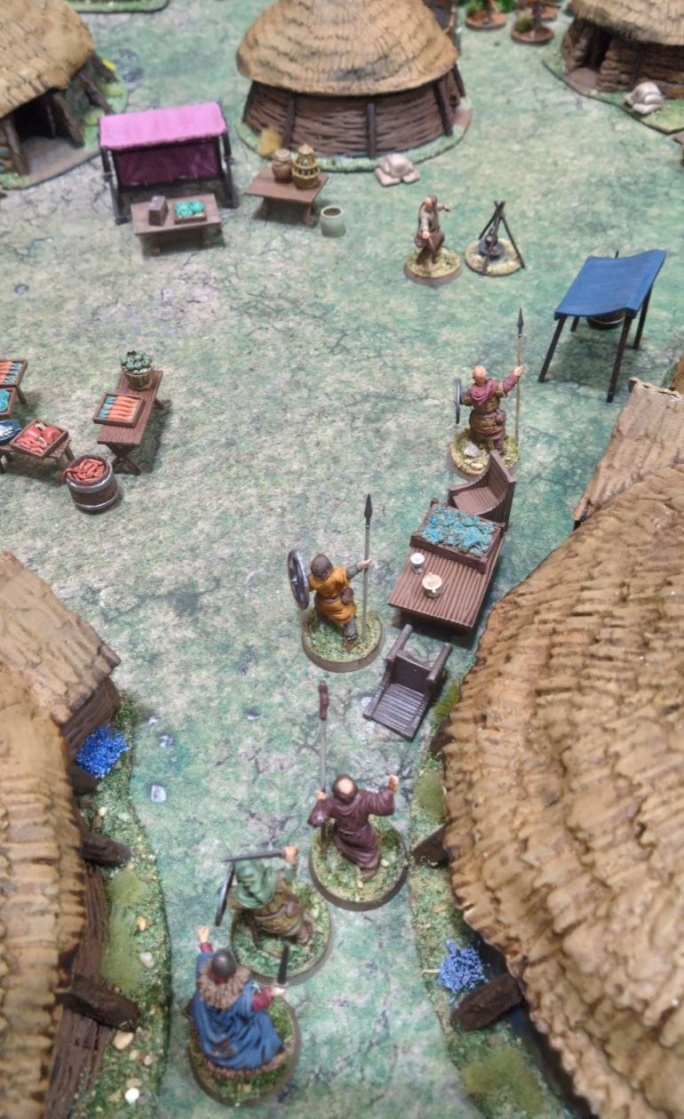 The Saxon chief and his cronies enter the village square
